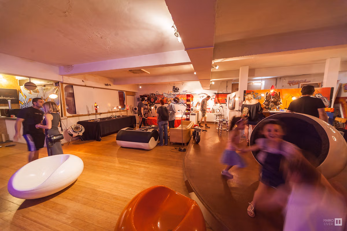 Vue d'ensemble d'un loft showroom au Qu4tre, enfants en mouvement entre mobilier design pop et fresques graffiti, espace d'exposition ludique et familial à Argenteuil