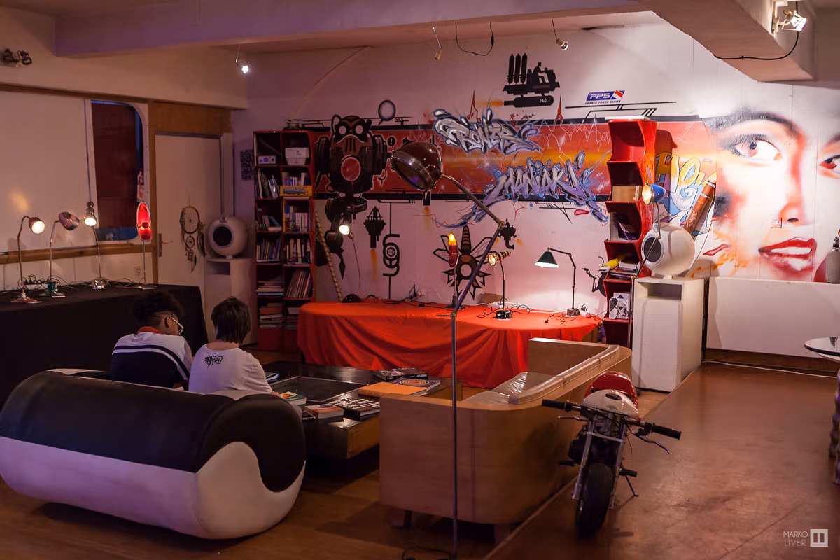 Atelier de design au Qu4tre, lampes artisanales et mobilier vintage, fresques graffiti et portrait réaliste sur les murs, univers créatif éclectique à Argenteuil