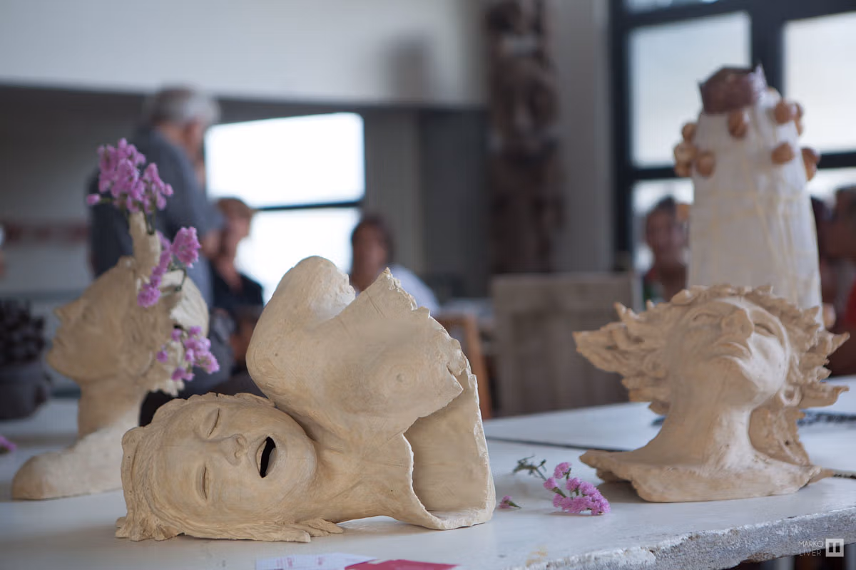 Sculptures en terre cuite figuratives exposées dans un atelier du Qu4tre, bustes et visages ornés de fleurs séchées, lumière naturelle de verrière, Argenteuil